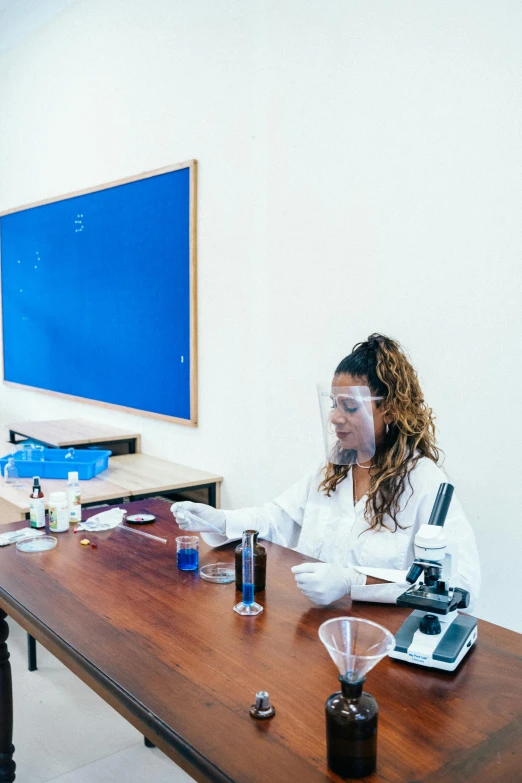 a group of people sitting around a wooden table, working in her science lab, candy treatments, profile image, blue