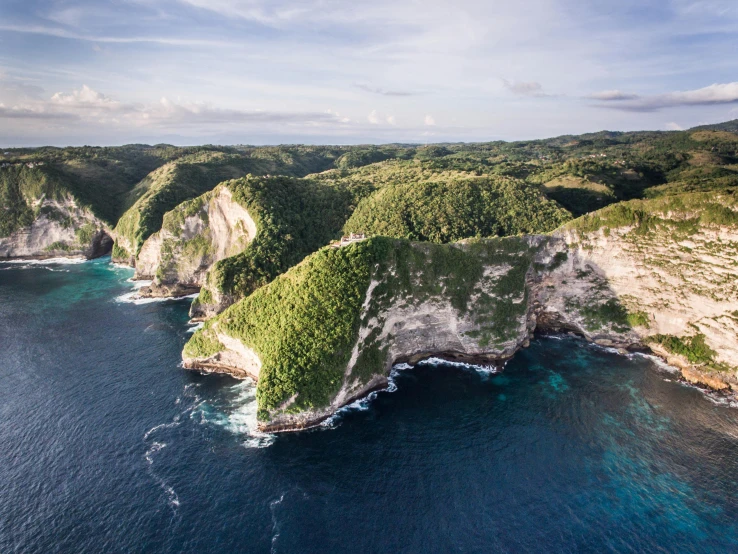 an aerial view of an island in the middle of the ocean, pexels contest winner, sumatraism, steep cliffs, epic coves crashing waves plants, tessellated planes of rock, marsden