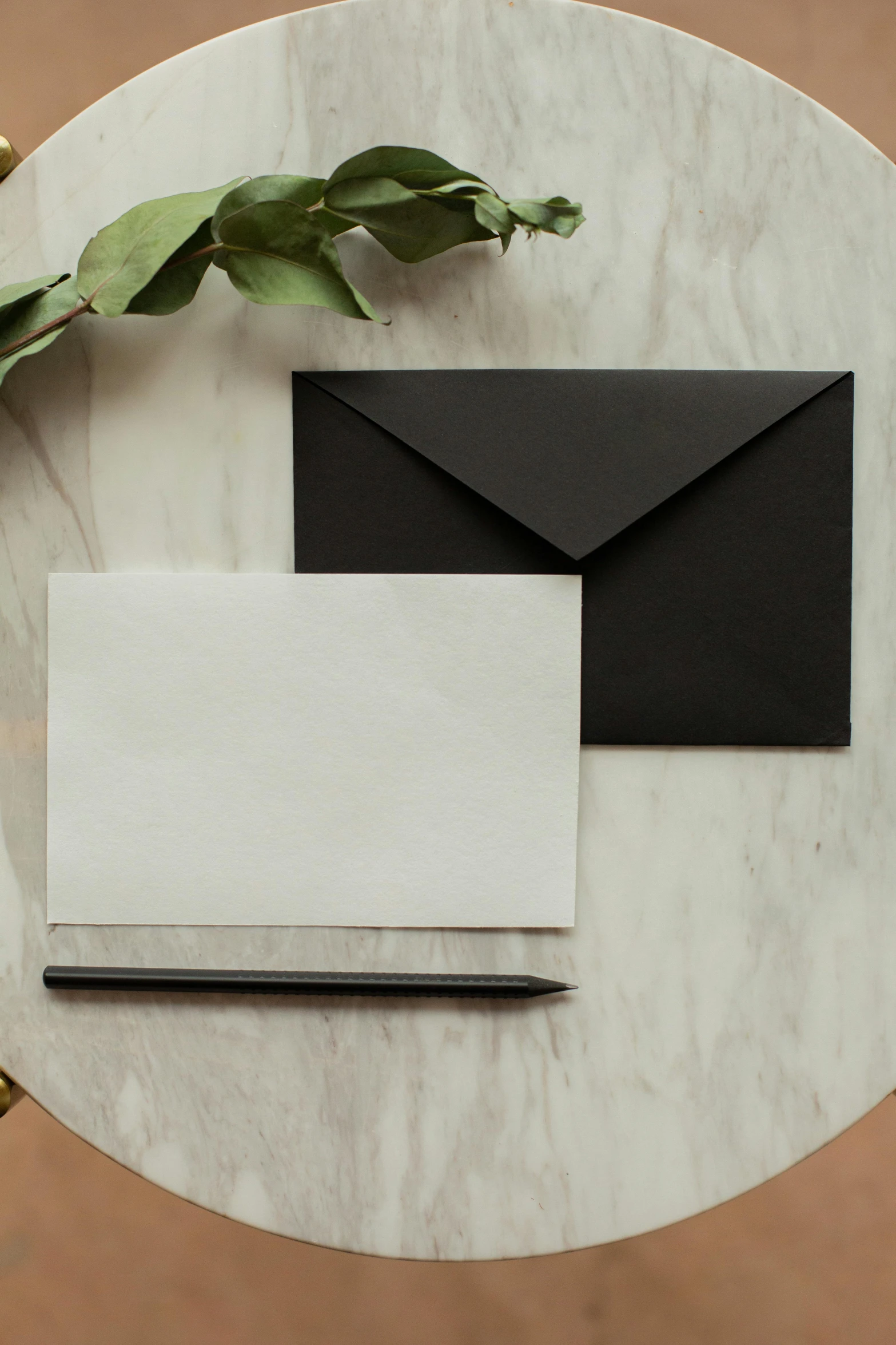 a black envelope sitting on top of a marble table, greeting card