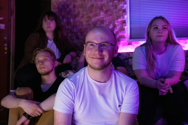 a group of people sitting next to each other, purple volumetric lighting, discord profile picture, felix englund, relaxing and smiling at camera