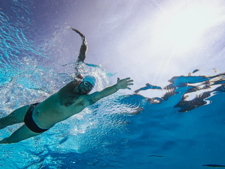 a man swimming under water in a pool, shot with sony alpha 1 camera, perfect crisp sunlight, rhys lee, ironman