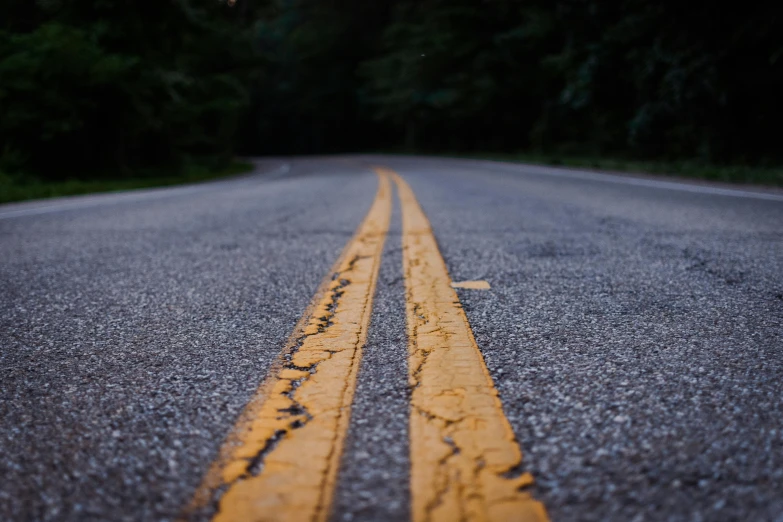 a double yellow line in the middle of a road, by Carey Morris, unsplash, fan favorite, damaged, 2 5 6 x 2 5 6 pixels, carved