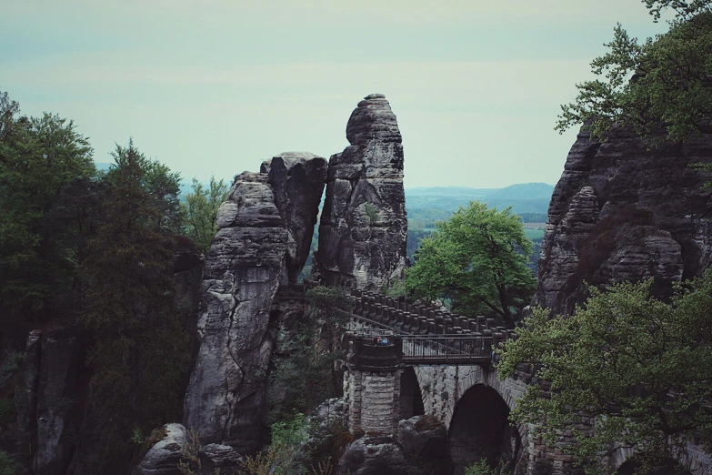 a group of people standing on top of a bridge, by Adam Marczyński, romanticism, rock formations, well preserved, instagram picture, lower saxony