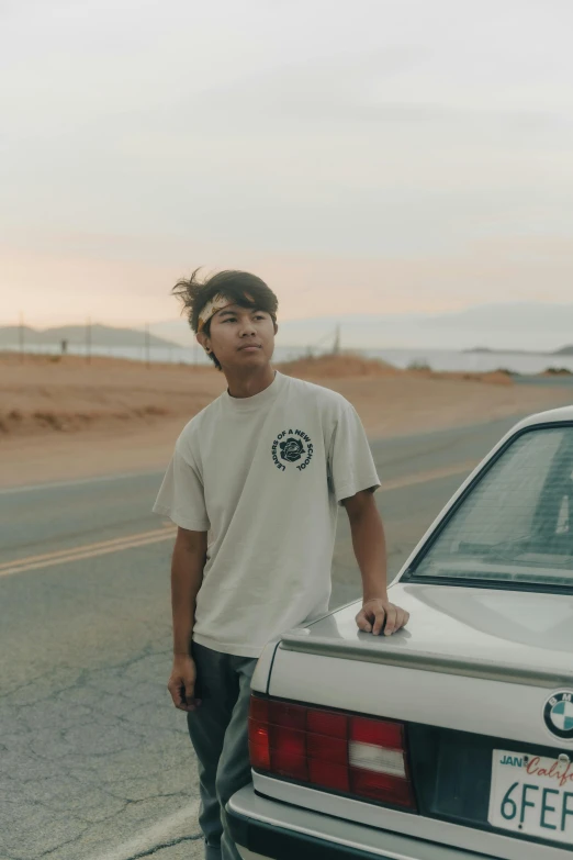 a young man standing next to a parked car, an album cover, inspired by John Luke, unsplash contest winner, dressed in a white t-shirt, pokimane, desertpunk, profile image