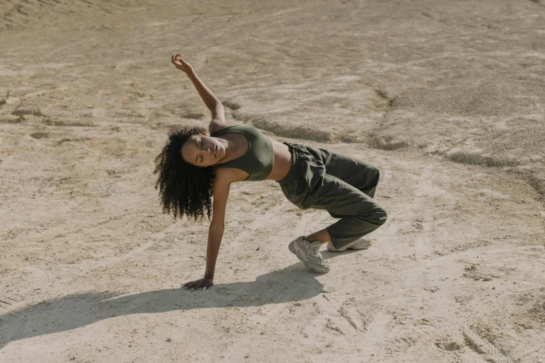 a woman doing a trick on a skateboard in the sand, trending on pexels, figuration libre, contemporary dance poses, standing on rocky ground, laying on the ground, imaan hammam