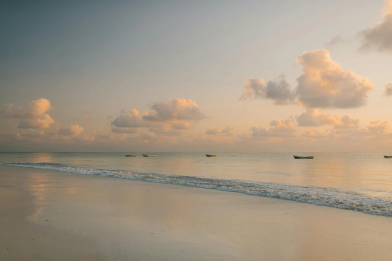 a couple of boats sitting on top of a sandy beach, unsplash contest winner, minimalism, somalia, humid evening, big sky, faded glow