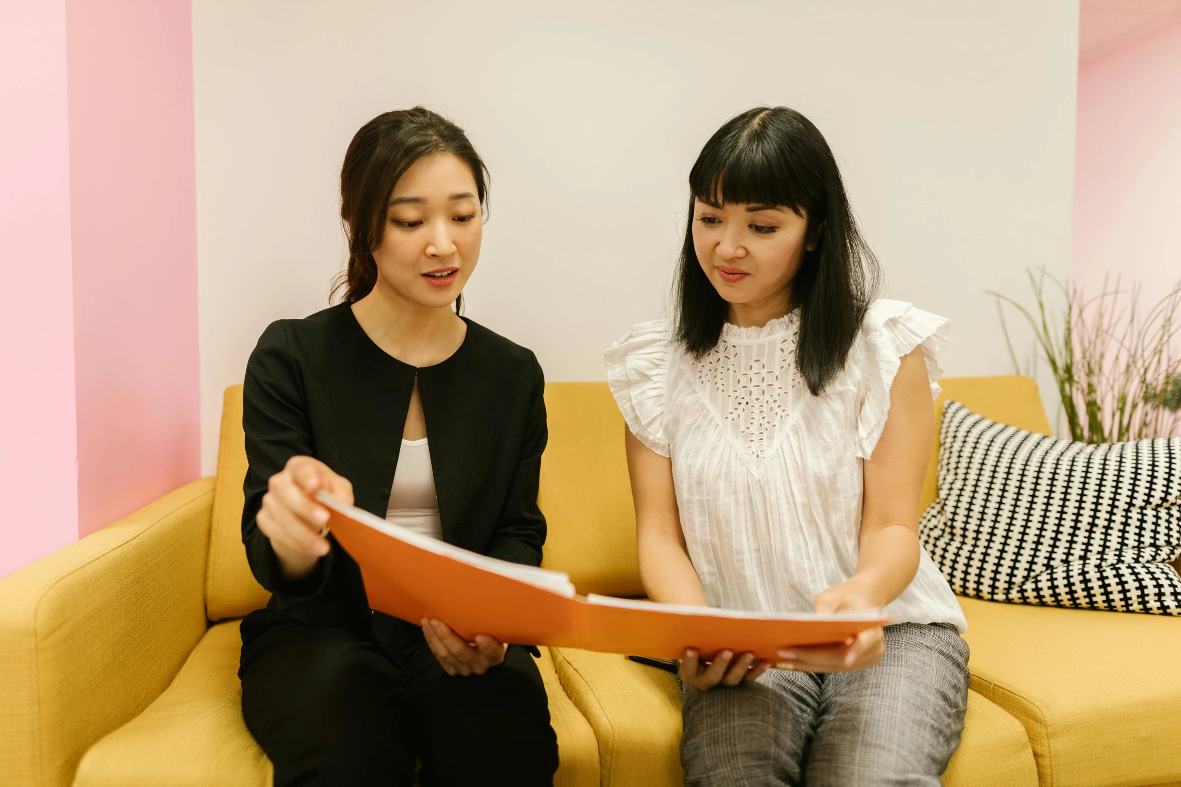 a couple of women sitting on top of a yellow couch, pexels contest winner, gutai group, holding notebook, ethnicity : japanese, in the office, profile image