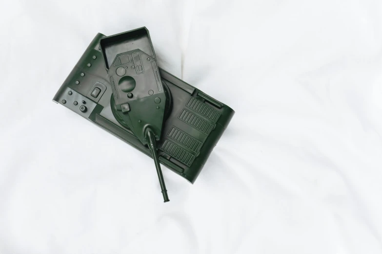 a close up of a game controller on a bed, by Adam Marczyński, military equipment, monochromatic green, vhs artefacts, holster