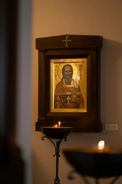 a candle sitting on top of a table next to a painting, orthodox icons, light coming from the entrance, portrait of samuel l. jackson, museum quality photo