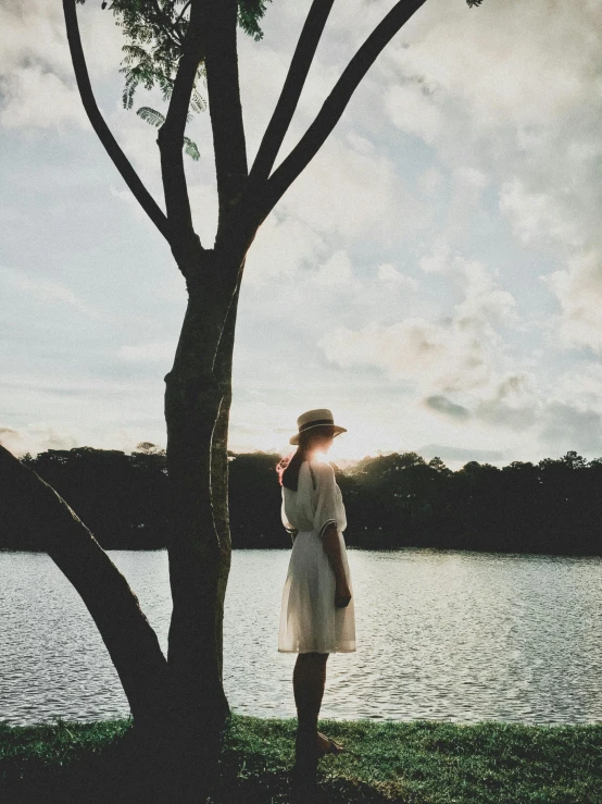 a woman standing next to a tree near a body of water, unsplash, happening, medium format. soft light, instagram picture, ilustration, without duplicate image