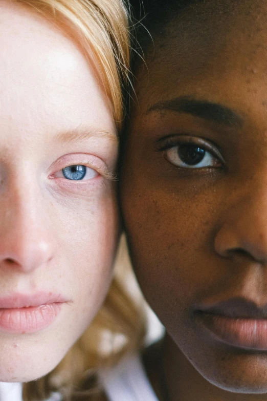 a couple of women standing next to each other, by Carey Morris, trending on unsplash, renaissance, spherical black pupils, light freckles, close up of a blonde woman, black teenage girl