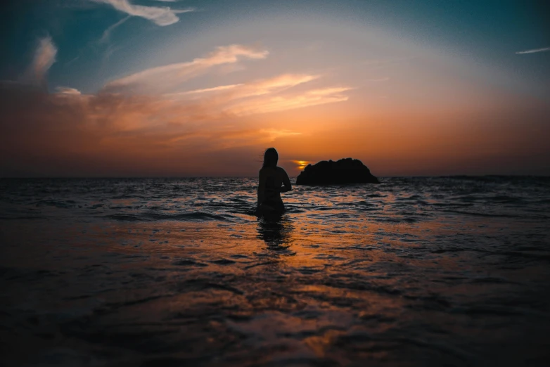 a person standing in the ocean at sunset, pexels contest winner, warm summer nights, instagram post, single figure, colored photo