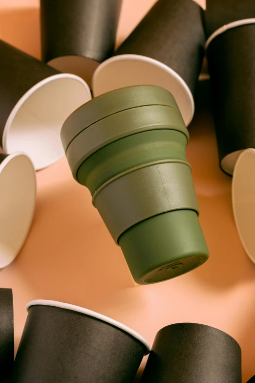 a pile of coffee cups sitting on top of a table, olive green, silicone skin, environmental shot, detailed product image