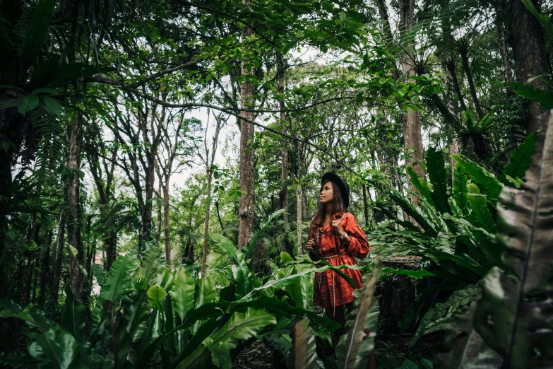 a woman standing in the middle of a forest, a portrait, by Julia Pishtar, unsplash, sumatraism, green and red plants, 🦩🪐🐞👩🏻🦳, nature growing around the city, wearing a hawaiian dress