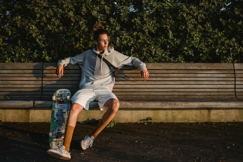 a man sitting on a bench with a skateboard, liam brazier, white clothing, thumbnail, lifestyle