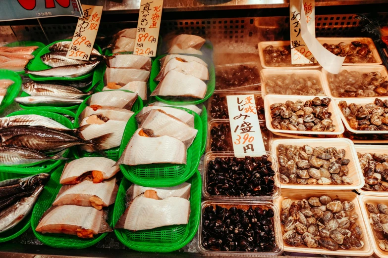 a display case filled with lots of different types of fish, by Julia Pishtar, trending on unsplash, mingei, china town, ingredients on the table, 2000s photo, inside a supermarket