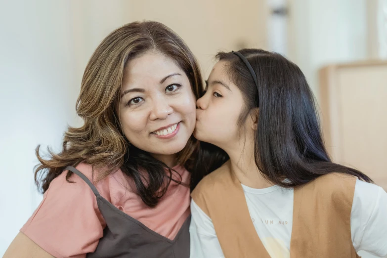 a woman giving a girl a kiss on the cheek, a picture, inspired by Ruth Jên, pexels contest winner, leni robredo, profile image, lovingly looking at camera, extra high resolution