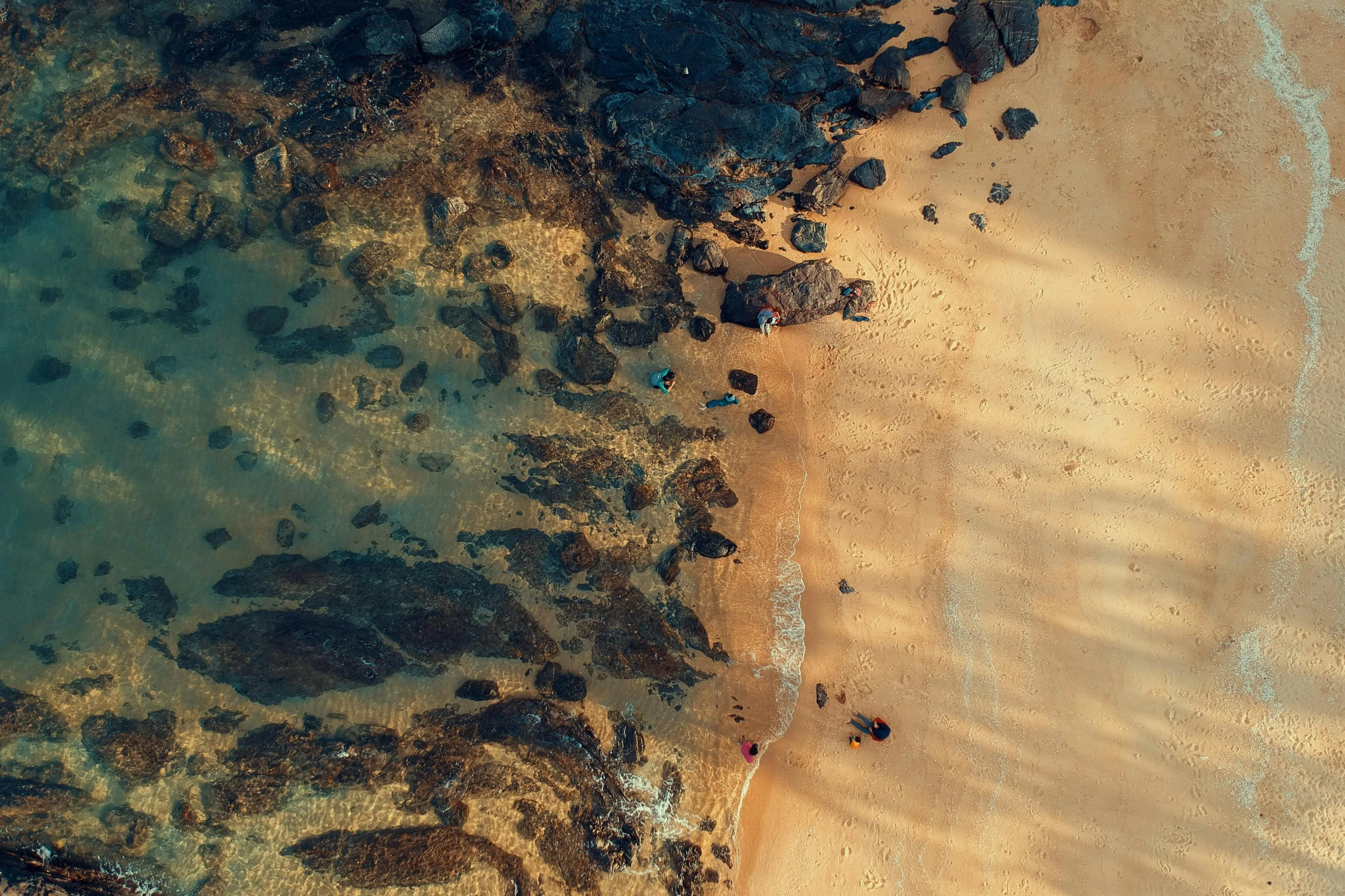 a large body of water next to a sandy beach, by Adam Marczyński, pexels contest winner, top-down shot, “ iron bark, rocky beach, hd footage