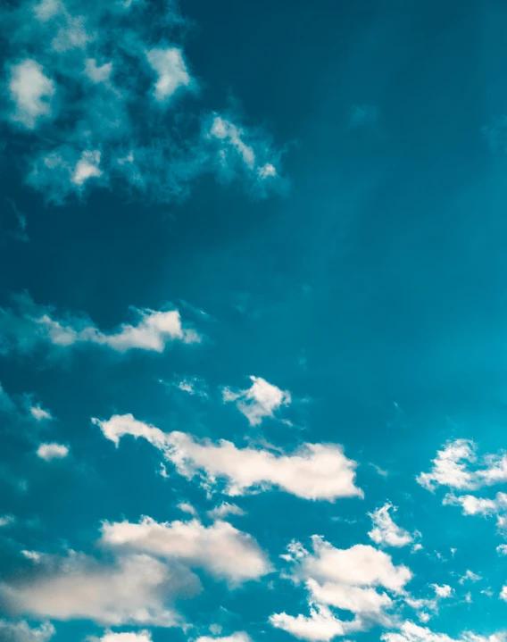 a plane flying through a blue cloudy sky, trending on unsplash, aestheticism, portrait photo