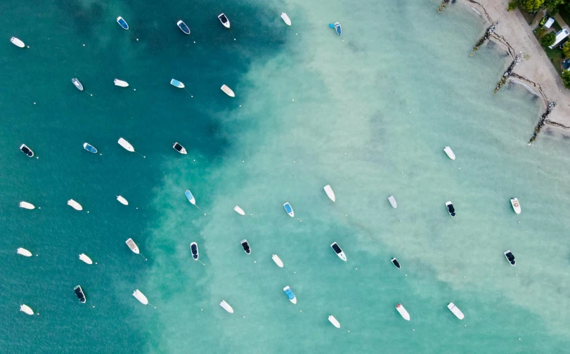 a group of boats floating on top of a body of water, by Peter Churcher, unsplash contest winner, minimalism, ocean pattern, teal tones, manly, white beaches