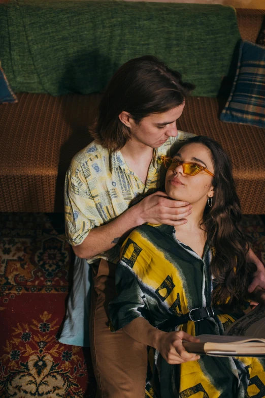 a couple of women sitting on top of a couch, by Jessie Alexandra Dick, trending on pexels, renaissance, androgynous person, making out, wearing gold glasses, film still promotional image