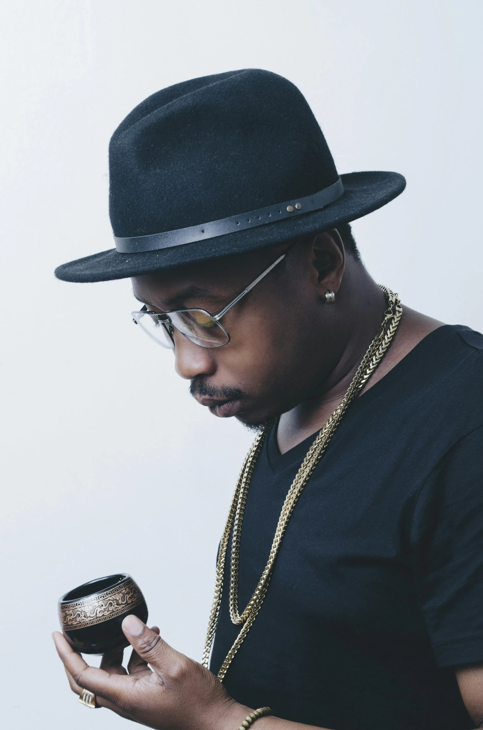 a man in a hat looking at his cell phone, an album cover, inspired by Zhu Da, unsplash, wearing gold glasses, square, “ golden chalice, looking to the right