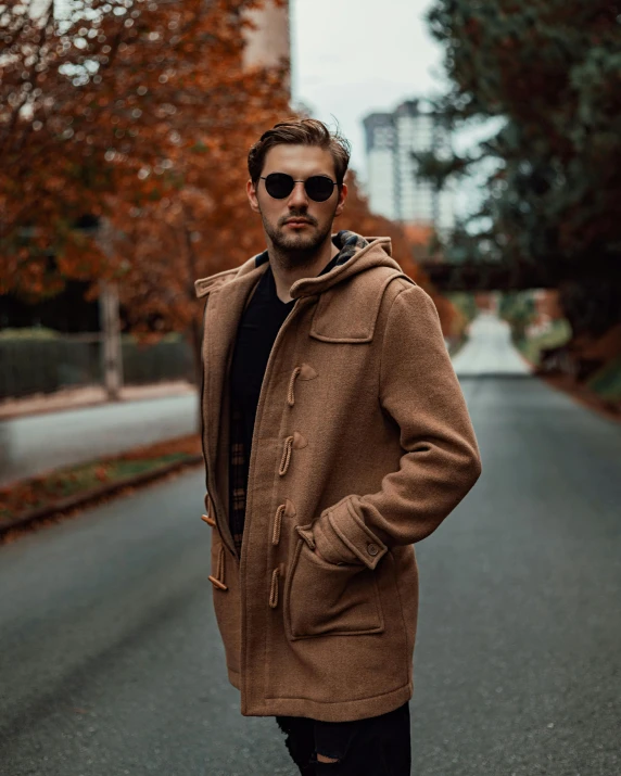 a man standing in the middle of a road, by Robbie Trevino, leather duffle coat, thumbnail, warm hue, half-body shot