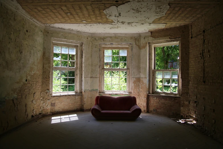 a red couch sitting in the middle of a room, an album cover, inspired by Thomas Struth, unsplash contest winner, abandoned derelict buildings, bay window, paul davey, july 2 0 1 1