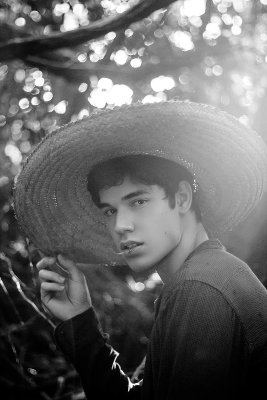 a black and white photo of a man wearing a hat, a black and white photo, unsplash, realism, young spanish man, in a jungle, ornately dressed, tommy 1 6 years old