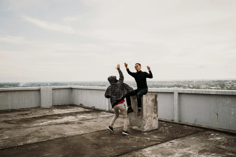 a couple of people standing on top of a building, pexels contest winner, happening, cute boys, leaping, nice slight overcast weather, vitaly bulgarov and mike nash