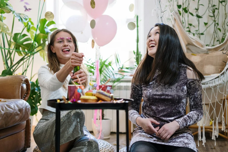 a couple of women sitting next to each other, pexels contest winner, happening, pals have a birthday party, background image, anna nikonova aka newmilky, asian female