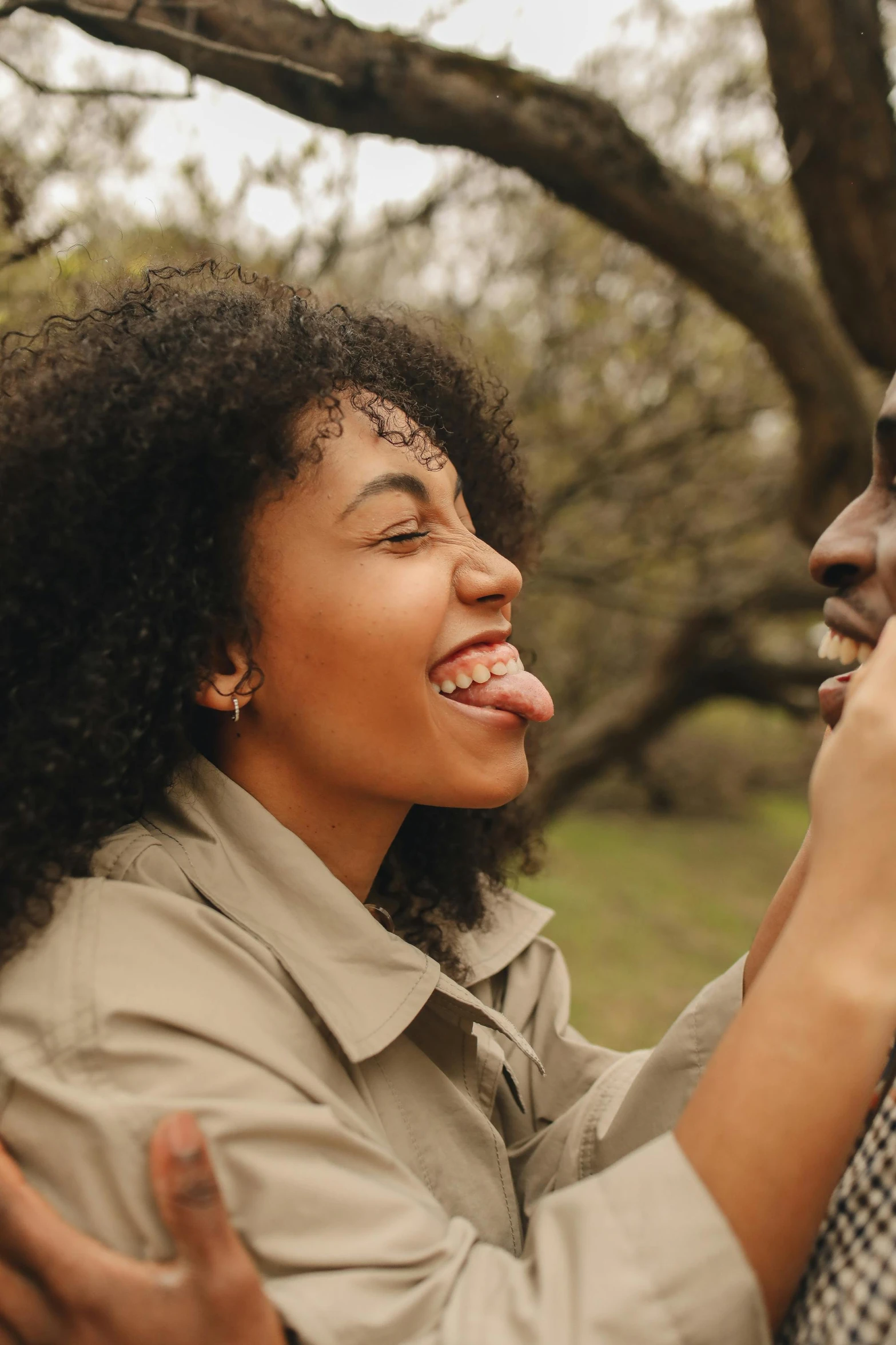 a man and a woman standing next to each other, trending on pexels, happening, licking tongue, brown skin like soil, smiling young woman, with a long