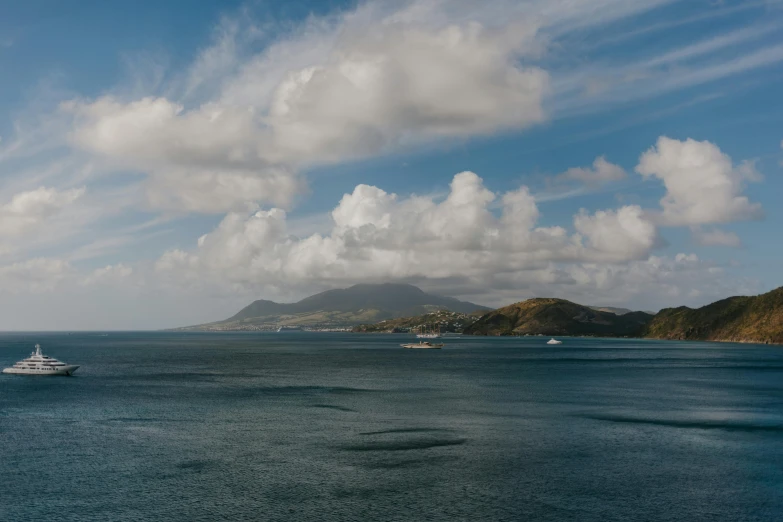 a large boat in the middle of a large body of water, a photo, pexels contest winner, happening, hills and ocean, te pae, distant clouds, caribbean