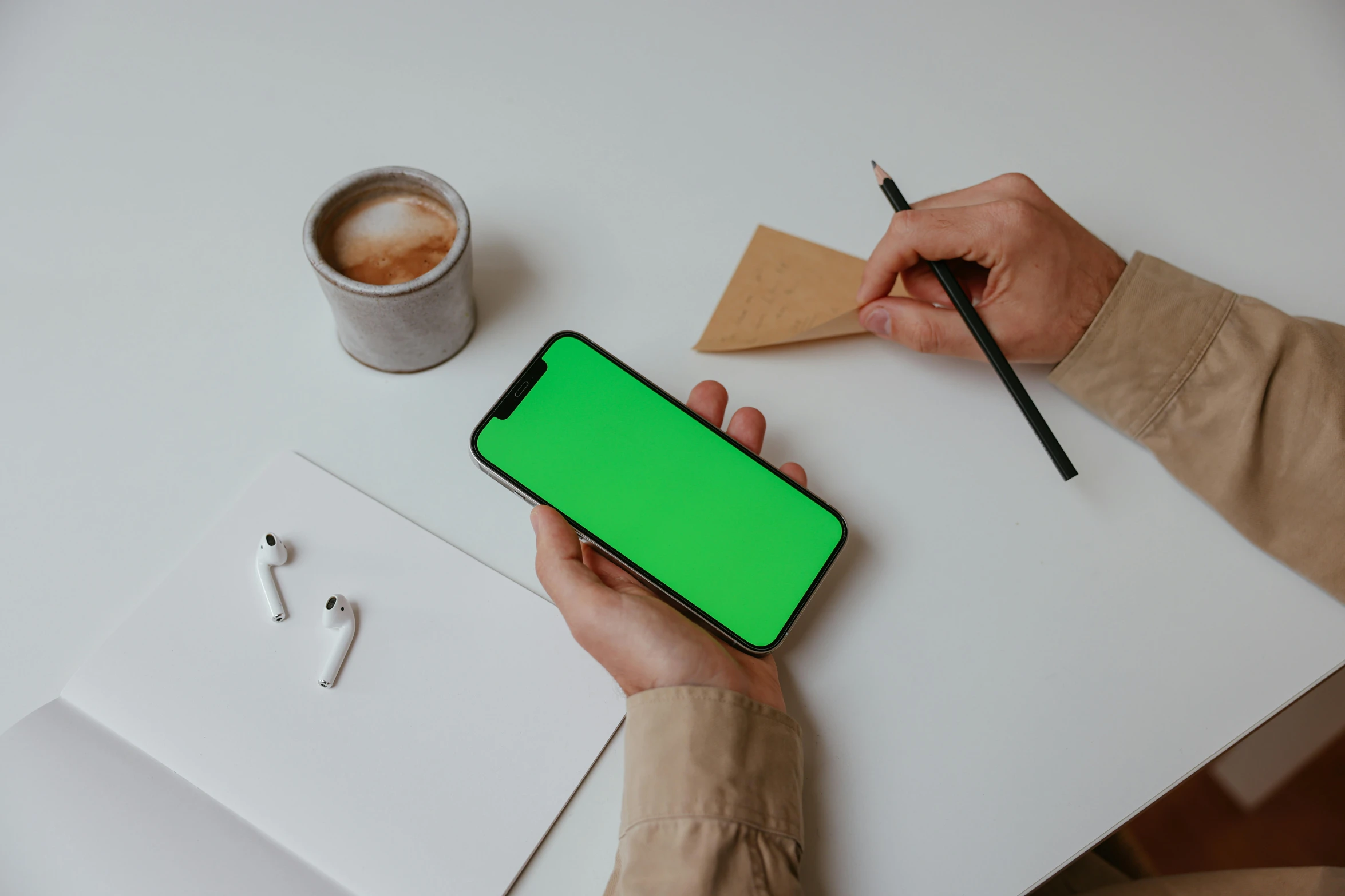 a person holding a phone with a green screen, a drawing, trending on pexels, sitting on a mocha-colored table, gradient green black, green square, no - text no - logo