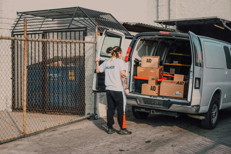 a man standing next to a van filled with boxes, pexels contest winner, post malone, avatar image, pokimane, mid - action