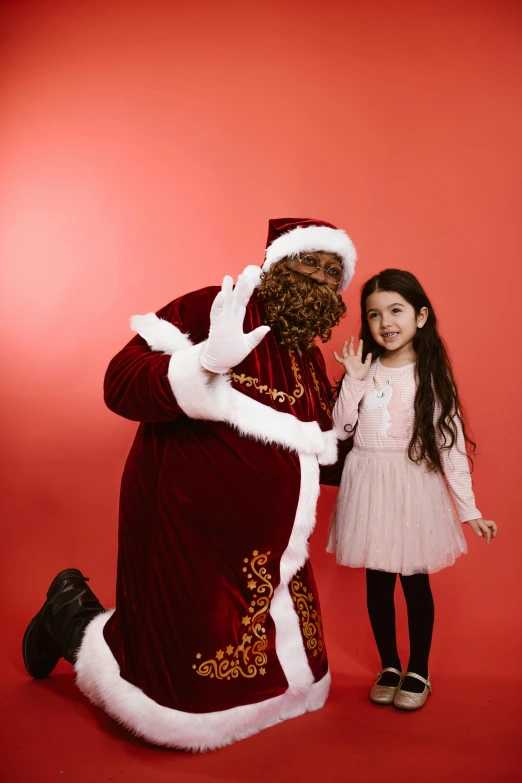 a little girl standing next to a santa clause, pexels, happening, solid background, brown, full frame image, gif