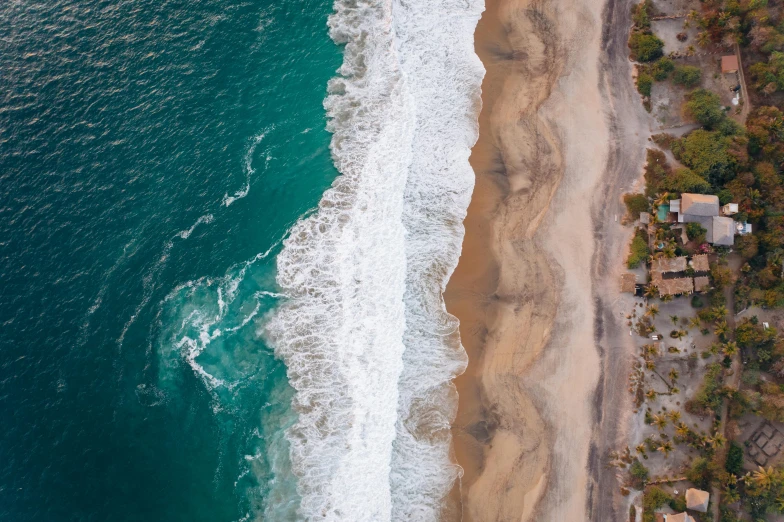 a large body of water next to a sandy beach, by Niko Henrichon, pexels contest winner, airborne view, half and half, oceanside, thumbnail