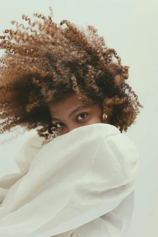 a woman with curly hair covering her face, trending on unsplash, willow smith zendaya, ignant, an all white human, muted colors. ue 5