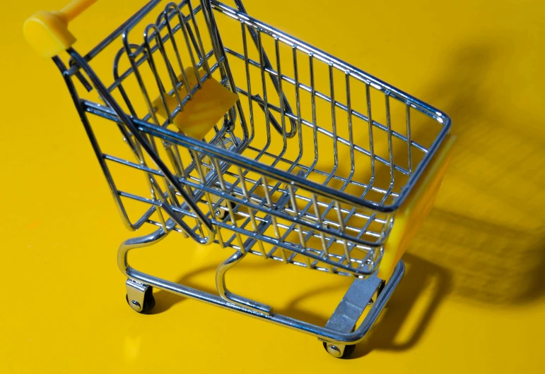 a miniature shopping cart on a yellow surface, pexels, hyperrealism, shiny silver, 🦩🪐🐞👩🏻🦳, rack, square