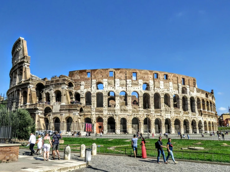 a group of people standing in front of the colossion, by Tom Wänerstrand, pexels contest winner, neoclassicism, colosseo, bright summer day, panorama, promo image