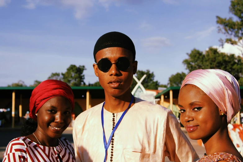 a group of three people standing next to each other, by Chinwe Chukwuogo-Roy, unsplash, wearing a turban, black teenage boy, dressed thobe, on a village