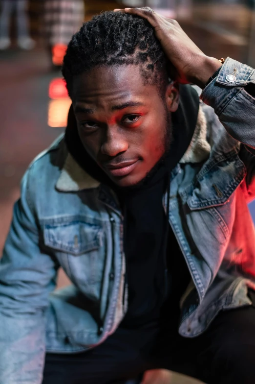 a man sitting on top of a red fire hydrant, an album cover, trending on pexels, wearing a turtleneck and jacket, ( ( dark skin ) ), multiple lights, confident pose