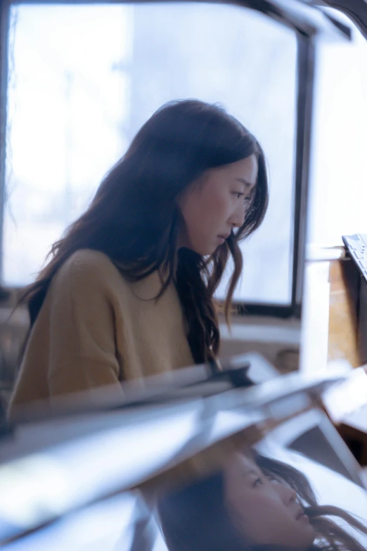 a woman sitting in front of a laptop computer, a picture, inspired by Li Di, trending on unsplash, side profile shot, female with long black hair, architect, pianist