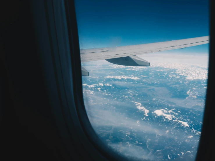 a view of the sky from an airplane window, pexels contest winner, sitting on a window sill, fused aircraft parts, earth on the window, thumbnail