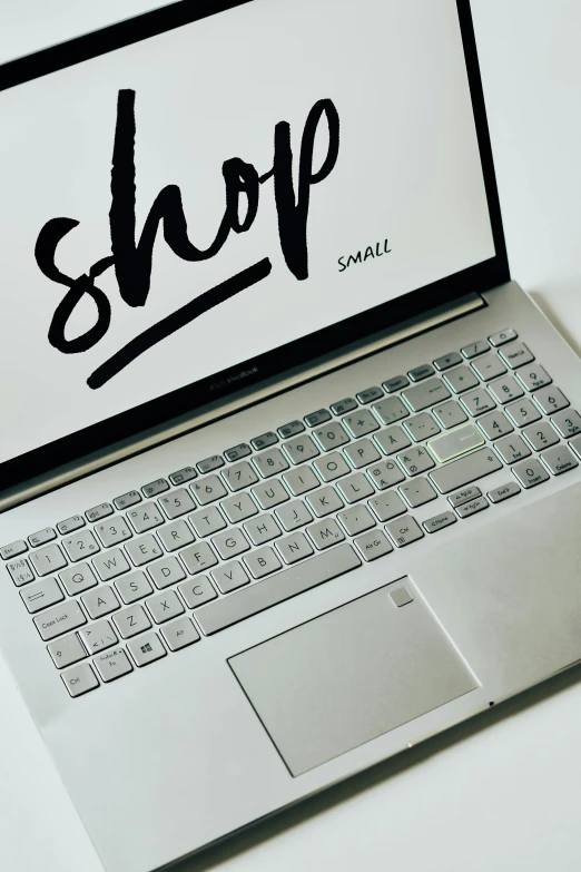 a laptop computer sitting on top of a white table, by Sam Black, trending on pexels, graffiti, shop front, grey and silver, home shopping network, a small