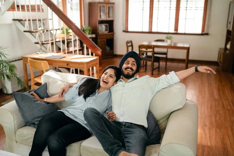 a man and woman sitting on a couch in a living room, inspired by Manjit Bawa, hurufiyya, having fun, single, highly upvoted, profile image