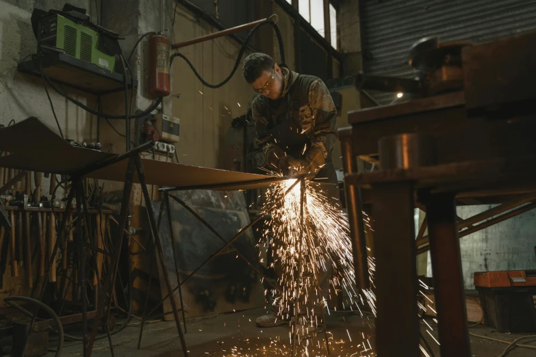 a man working on a piece of metal, by Thomas Furlong, pexels contest winner, full body hero, low quality footage, profile pic, brown