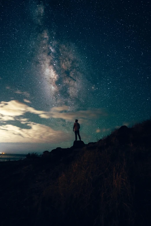 a person standing on a hill looking at the night sky, trending on unsplash, light and space, multiple stories, big island, astronaut standing looking, ( ( ( ( kauai ) ) ) )