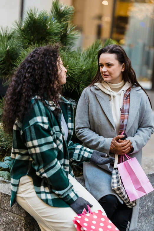 two women sitting on a bench talking to each other, happening, holiday season, woman in streetwear, curly haired, promotional image