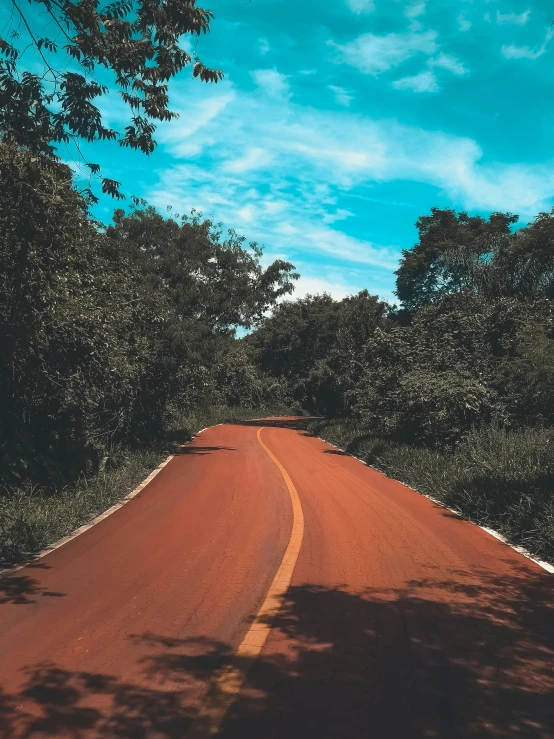 a red road surrounded by trees under a blue sky, an album cover, by Byron Galvez, pexels contest winner, sumatraism, 🚿🗝📝, thumbnail, orange, very asphalt